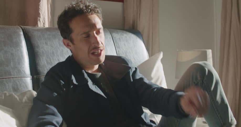 A man sitting on a bed with a laptop