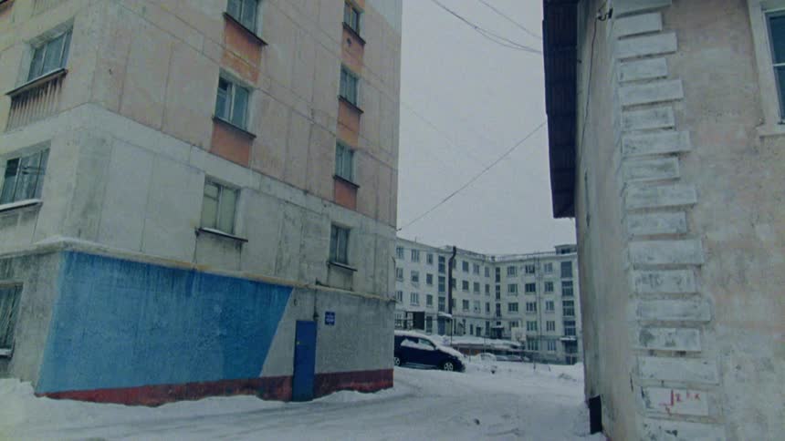 Its snowing in an urban city with apartment buildings