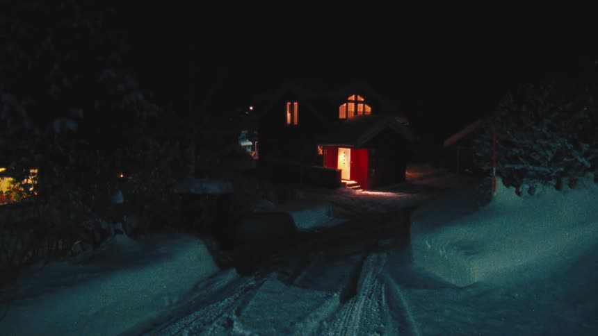 Illuminated countryhouse in the snowy countryside at night