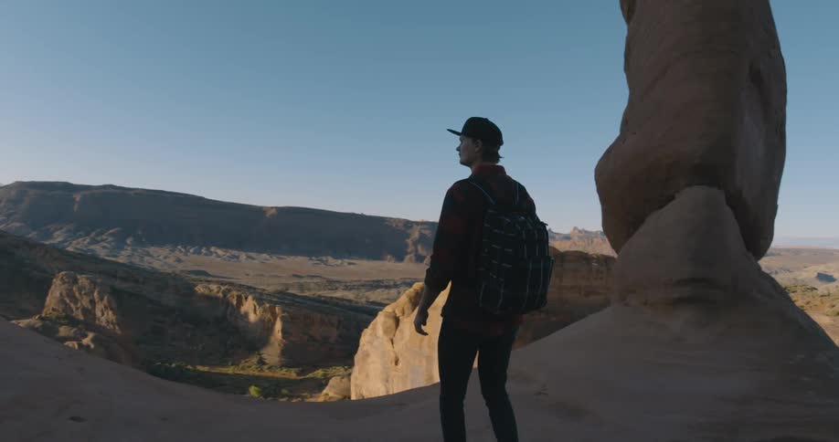 A man takes in the view as he walks through a canyon