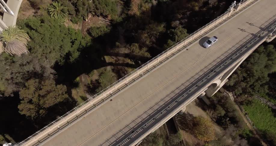 Overhead view of car driving over bridge