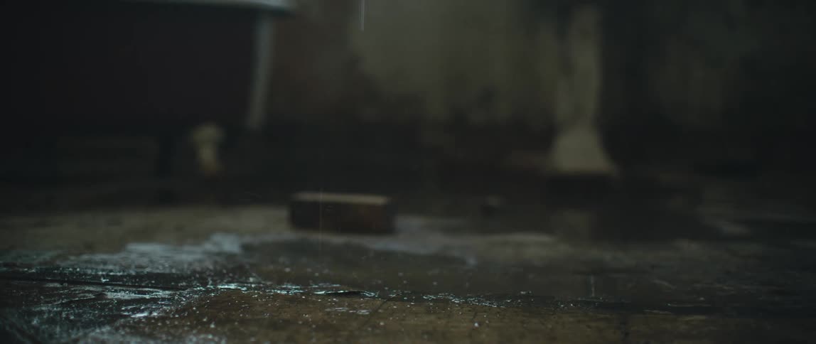 Water drips and splashes on the floor near a clawfoot bathtub