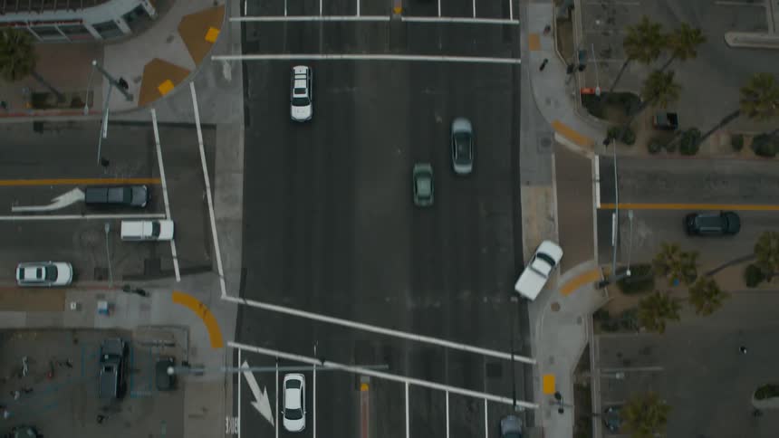 Aerial view of traffic in town near buildings and parking lots