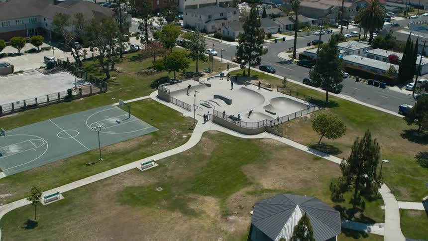 People ride skateboards at skate park area of park in small town