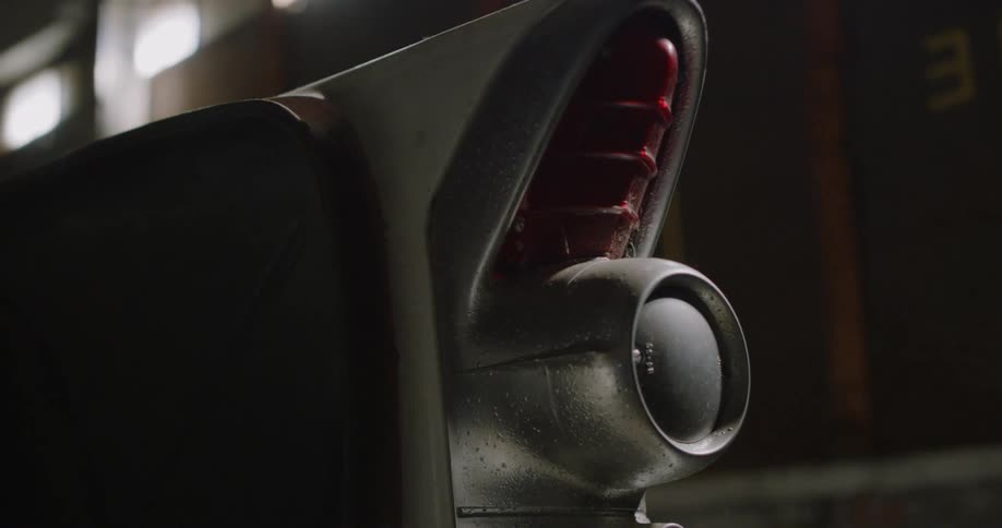 A dust covered vintage taillight next to a tire