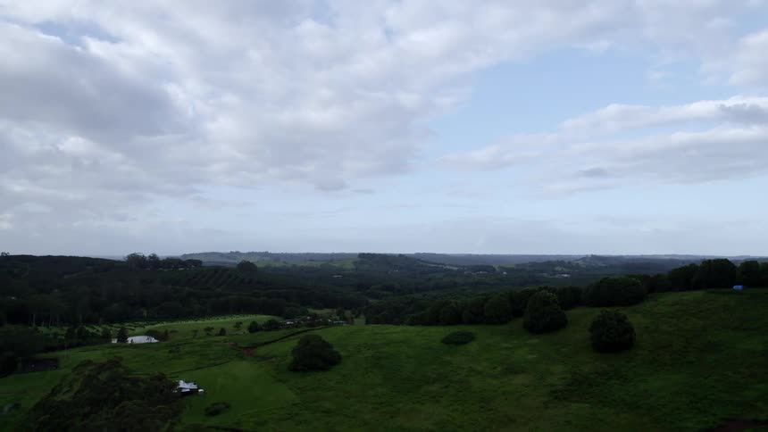 Aerial view of the green grass on the slopes of the hills in the countryside at morning