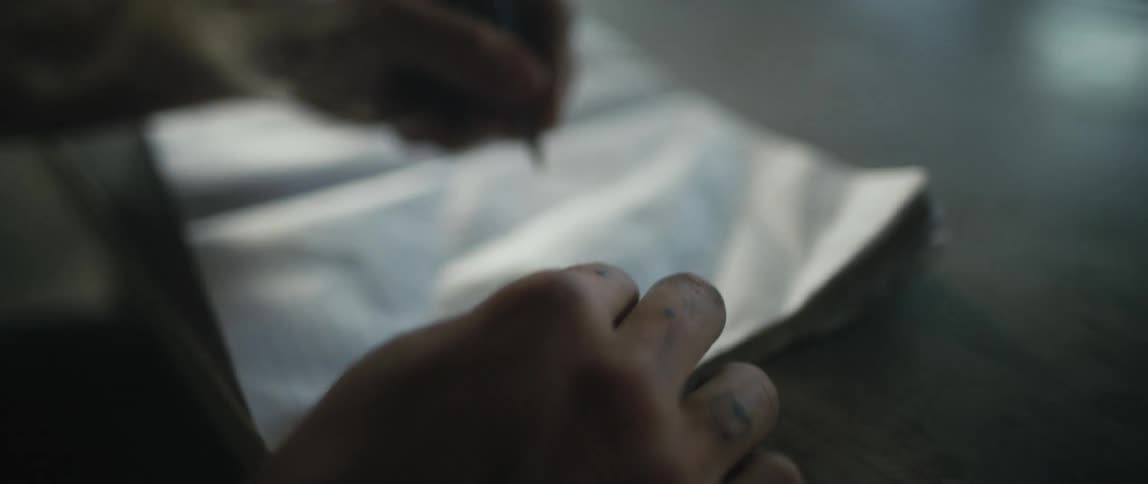 A person is writing in the notebook