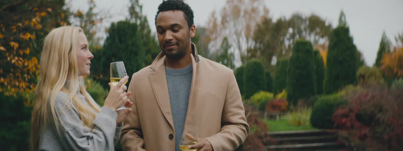Attractive couple cheers in a garden with fall color