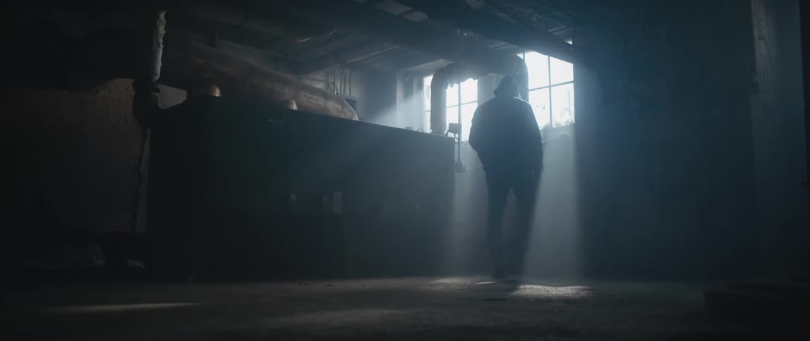 A man is standing in the dark basement