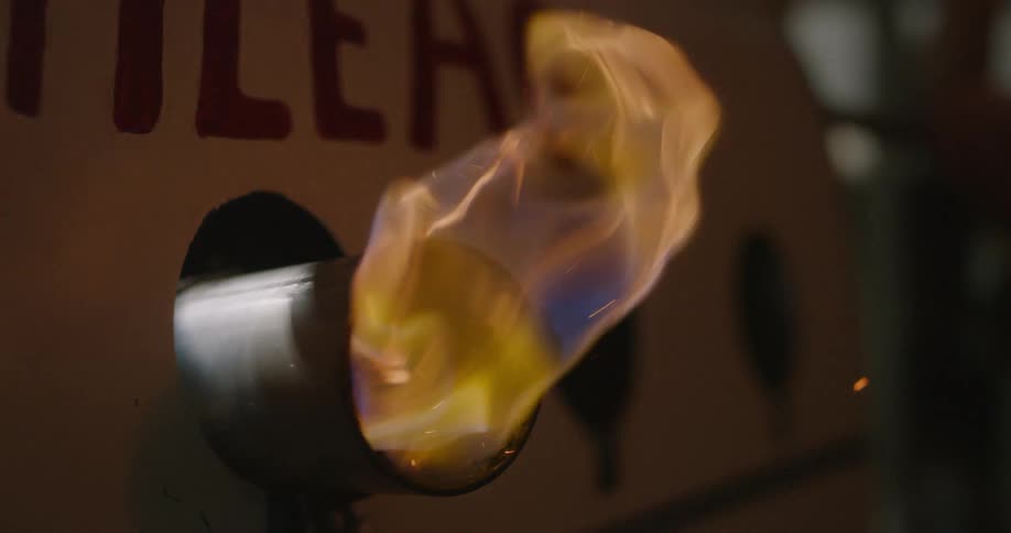 Flames emerge from the exhaust pipe of a car