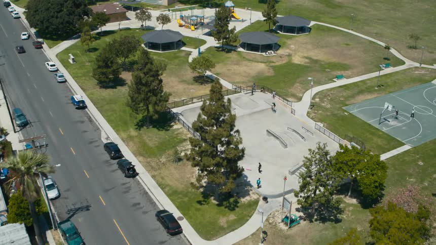 People playing basketball and skateboarding in a neighborhood park