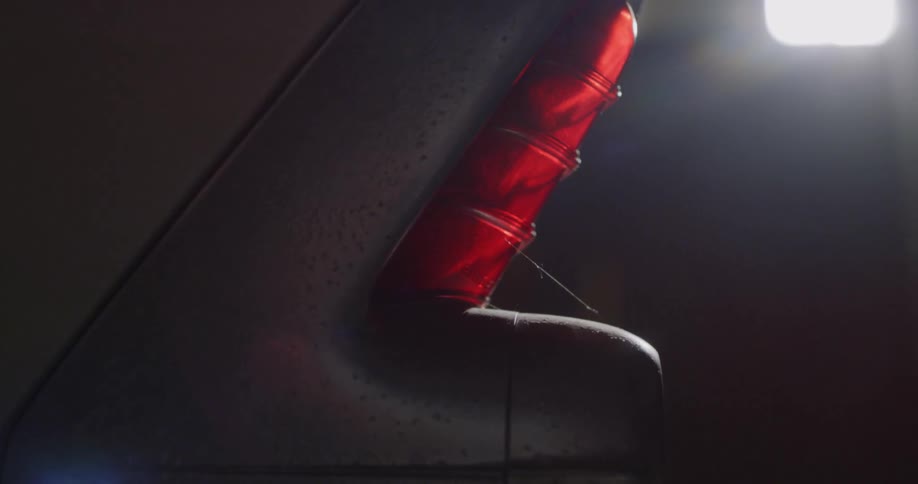 Red tail light at the back of a rusty old vehicle