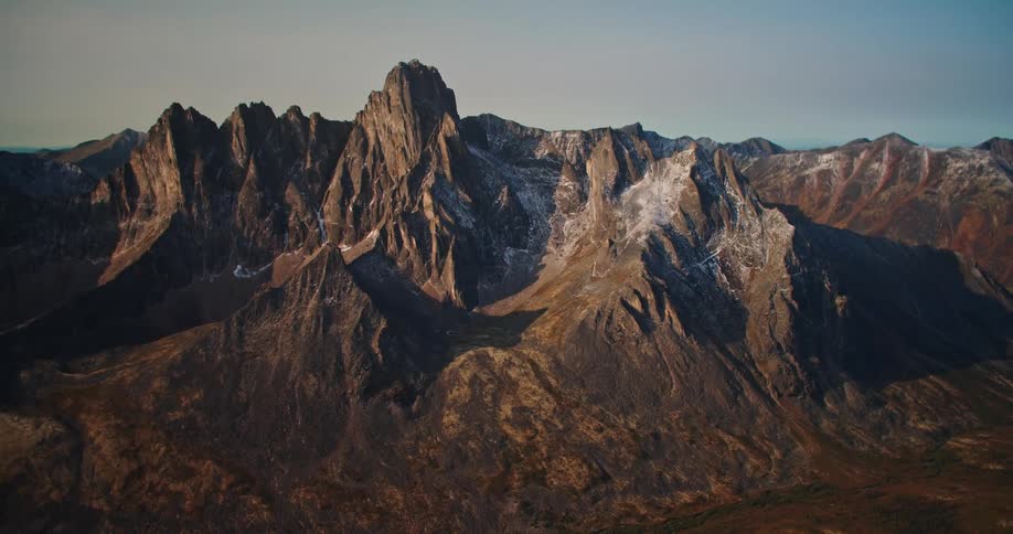 A mountain ridge with rough peaks reaching high in a clear sky