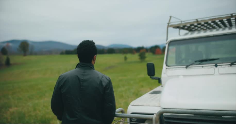 Walks toward his car in a field
