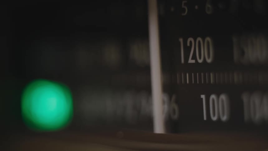 Setting indicator moves back and forth across number tick marks as light shines green