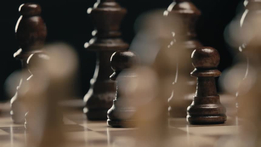 Wooden chess pieces on a chess board in a dark place