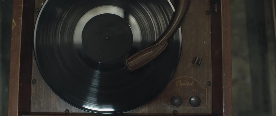 A vinyl album spins on a wooden record player