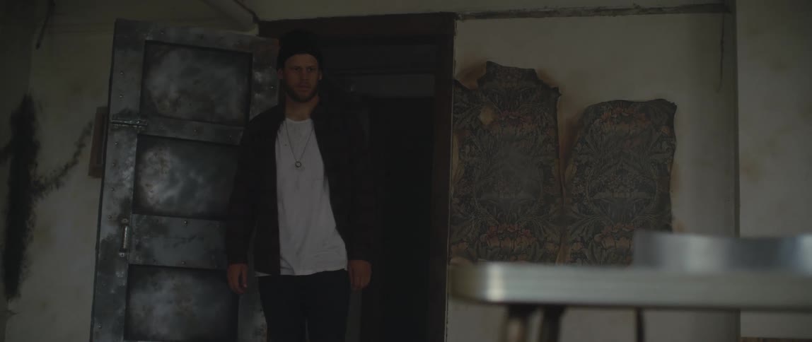 A man walks into a room in a dilapidated building