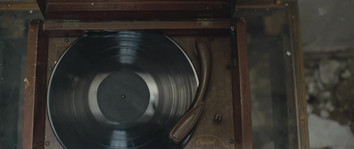 A vinyl record album plays on an old turntable