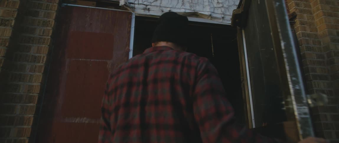 Man wearing a knit hat enters a building