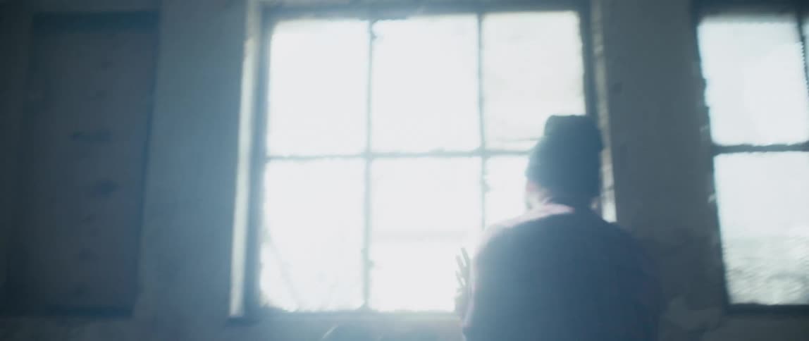 Man walks back and forth through abandoned building as he yells