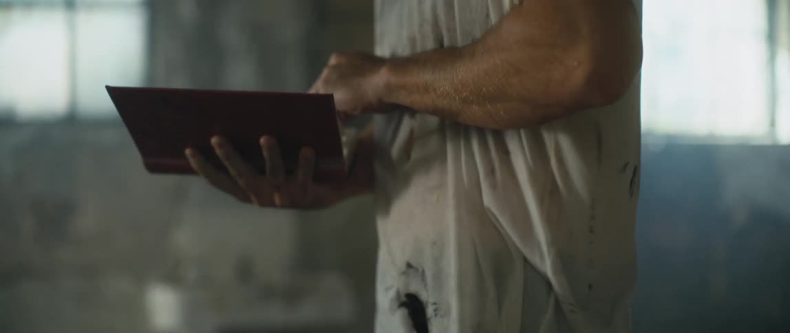 Man angrily tears pages out of a book and crumples them up and drops them