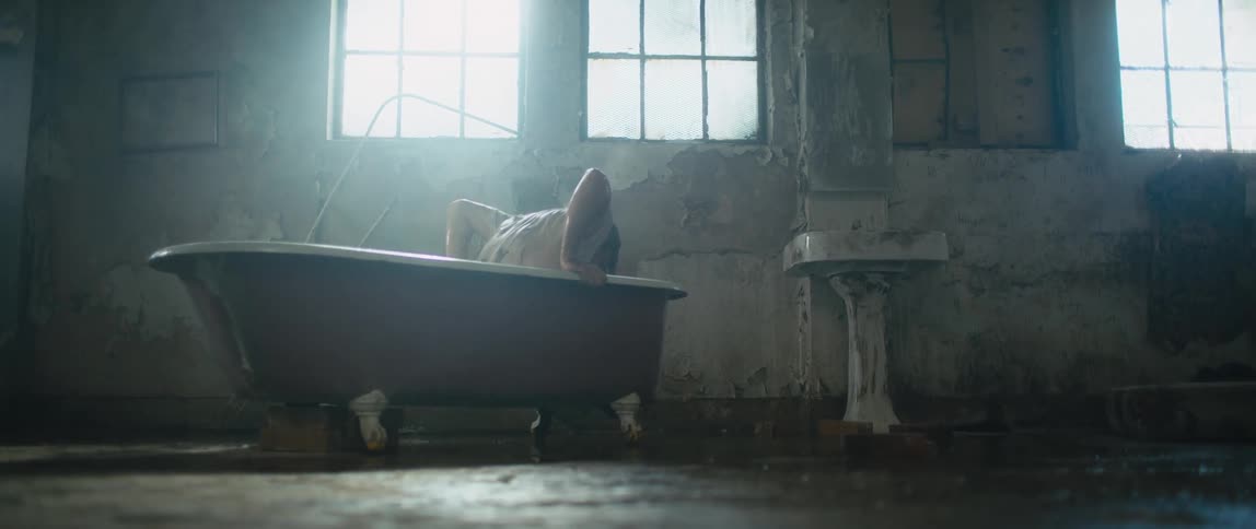 A person gets up from the water in the tub