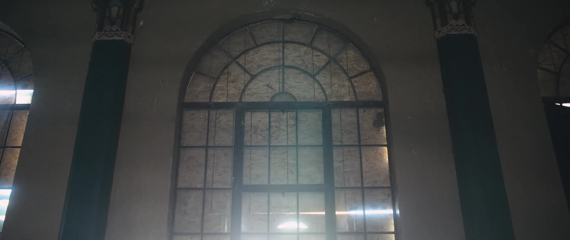 Light shines through the arched windows that have many sections