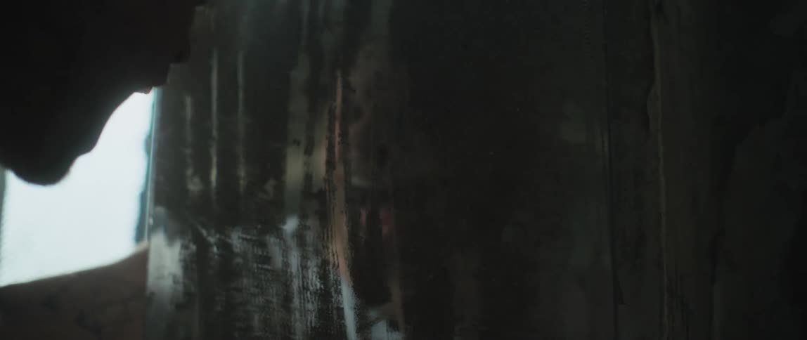 Person screams and hits dirty scraped up reflective surface near window