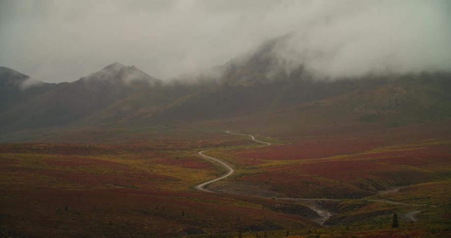 View of autumn meadow with cloudy mountains