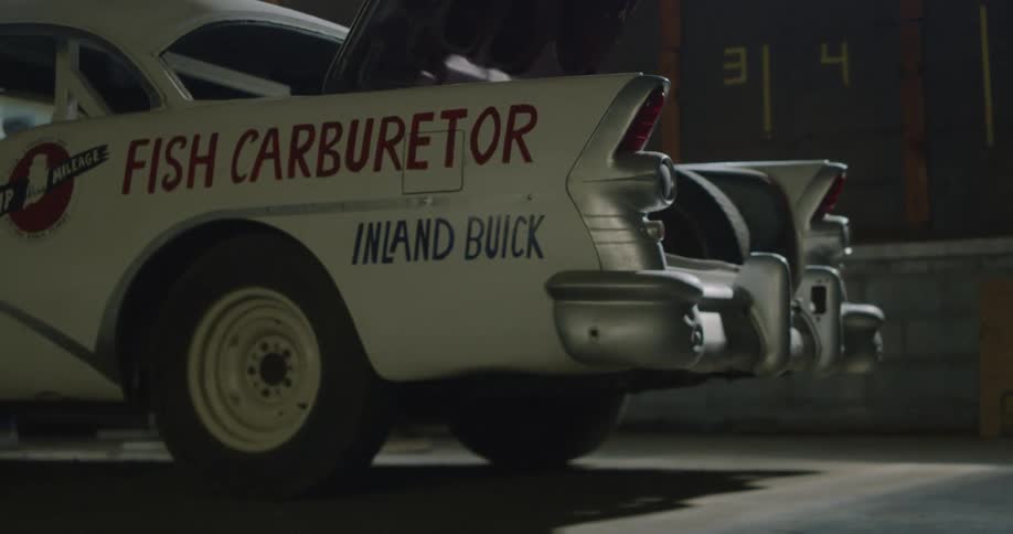 A vintage vehicle sits in a parking lot