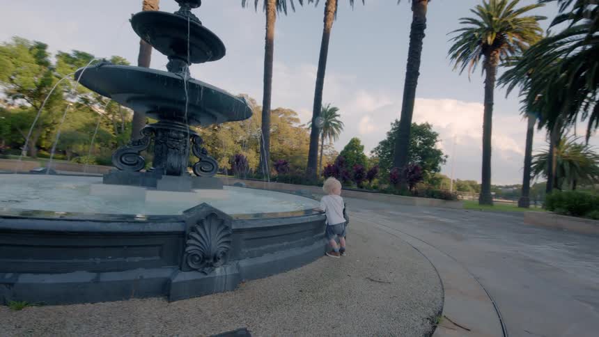 A view of a child looking into a fountain