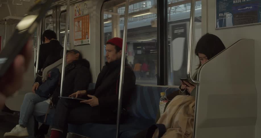 Man uses and closes his laptop and stands up while traveling on a train