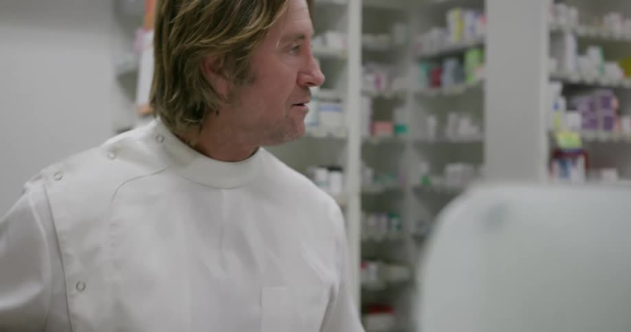 A man is mixing something in the pharmacy