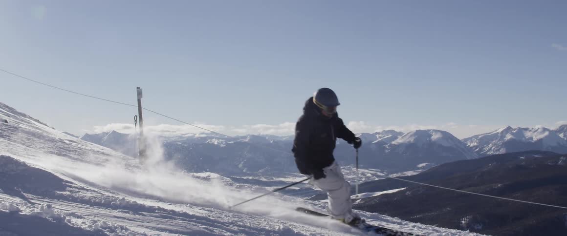 A skier descending a ski slope