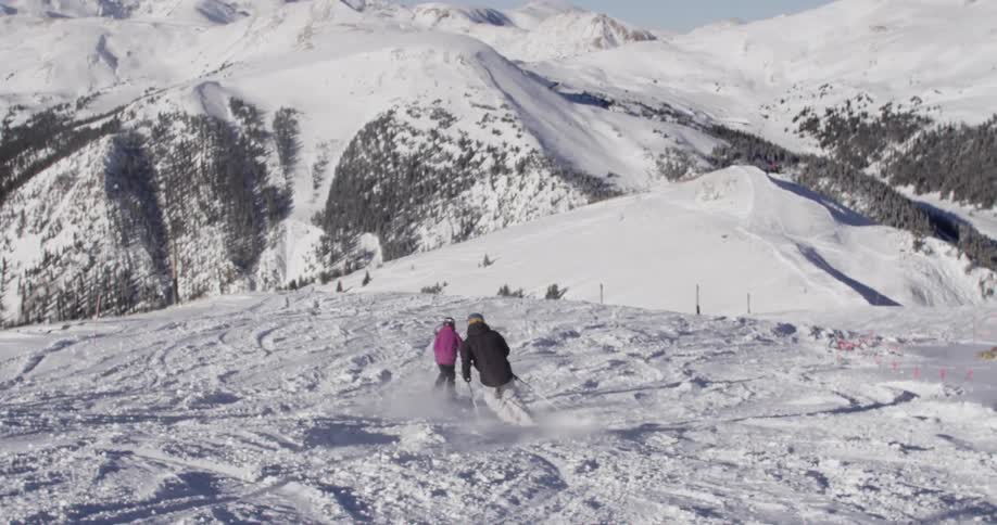 Two people skiing down a mountain