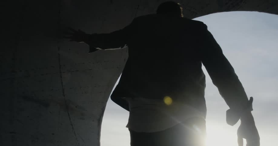 A man walks through a concrete tube