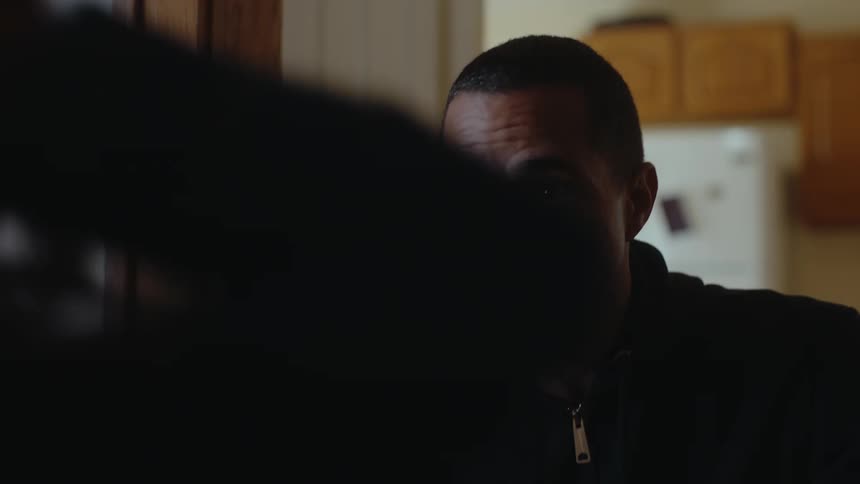 A man at home talking sternly to another person who jumps up in frustration