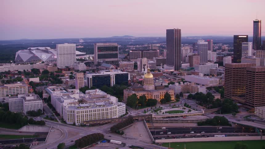 An aerial view of cars driving past high rise office buildings in a city