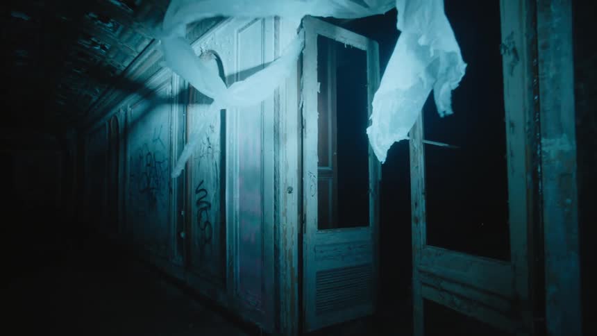 Light shines on a curtain waving in the hallway of an old abandoned dilapidated building