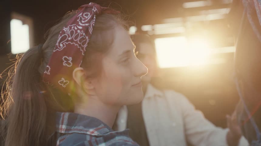 Two women petting a horse in a barn smiling and looking awed