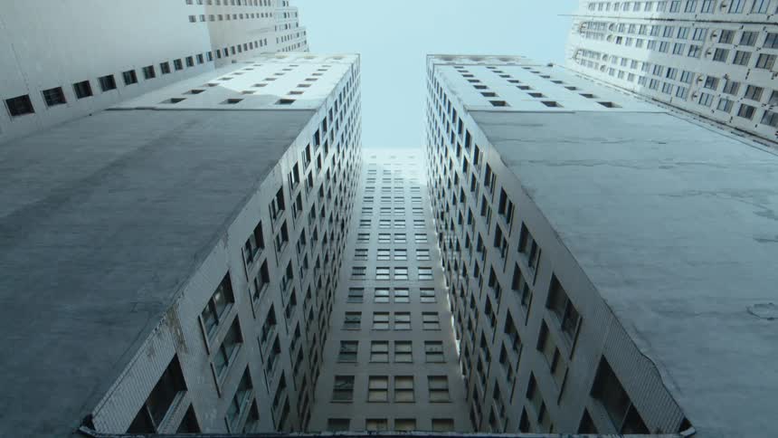 A van pulls up next to a high rise office building