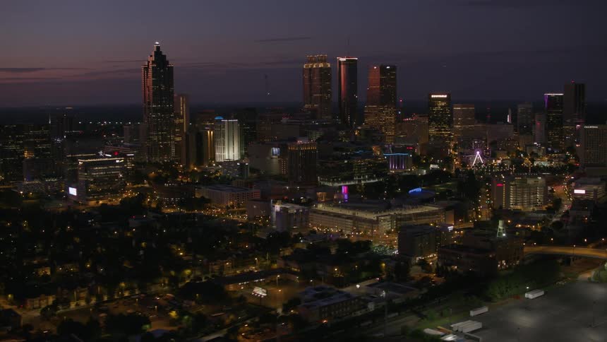 City stretches to horizon under a purple and pink tinted sky at night