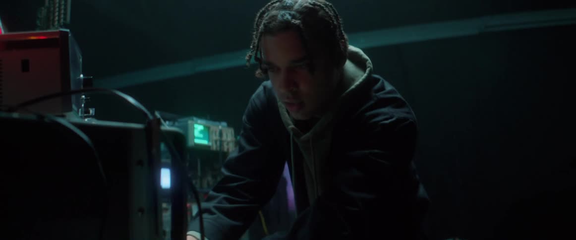 Man adjusts machine settings standing in front of series of screens and scientific machines