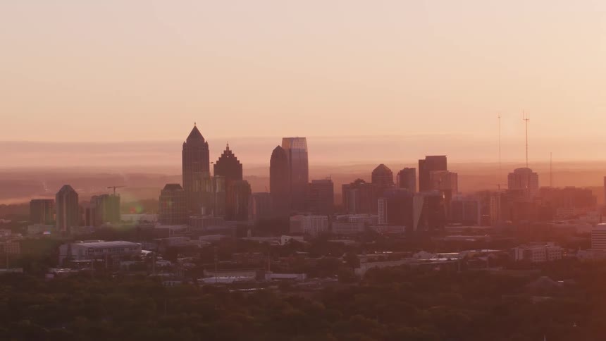Rising sun turns haze obscuring city skyline red