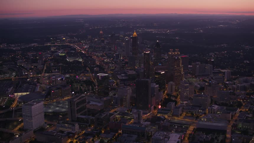 Skyscrapers loom over a metropolis at sunset
