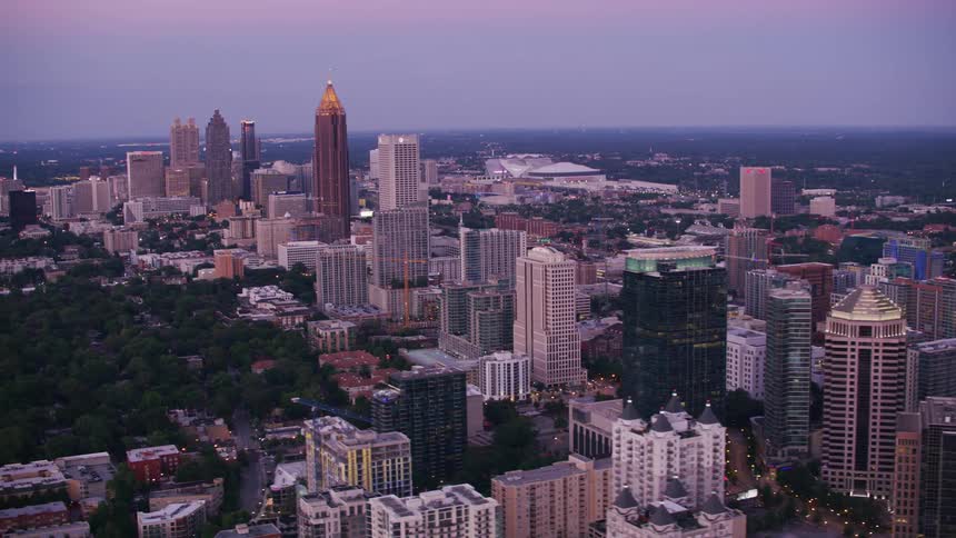 Aerial view of a downtown city at dusk is displayed