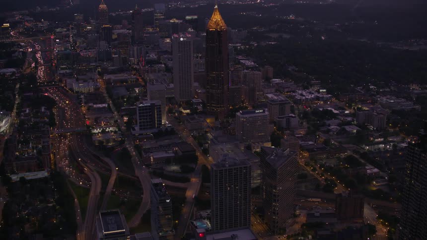 Dense traffic flows along highways through downtown passing landmark