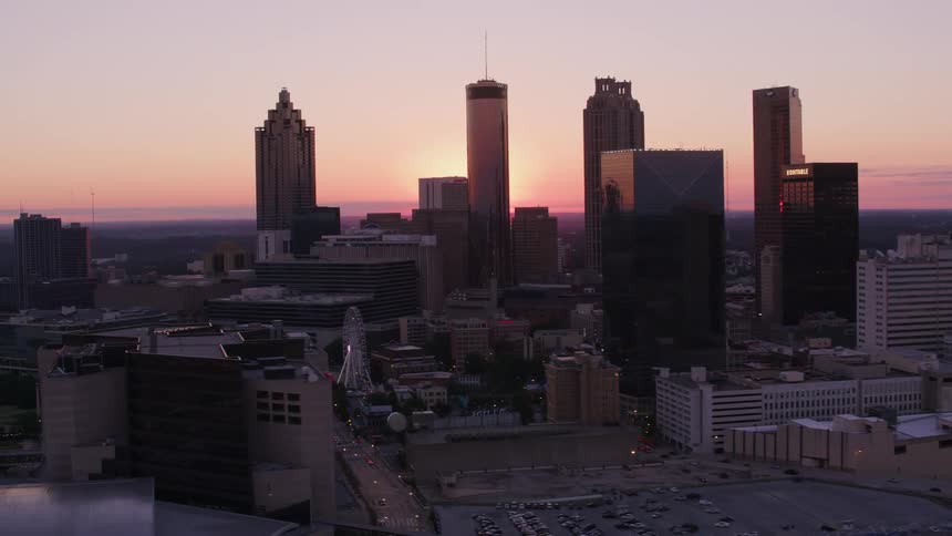 Aerial view of the skyscrapers on the city skyline in front of the sun setting over the horizon