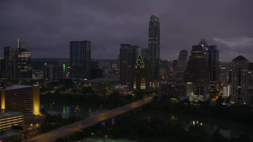 Aerial view of the city downtown skyline near a river crossed by bridges at evening